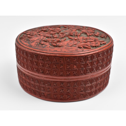 69 - A Chinese Qing dynasty carved cinnabar lacquer box, of cylindrical form, the lid with intricately de... 