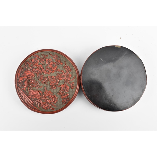 69 - A Chinese Qing dynasty carved cinnabar lacquer box, of cylindrical form, the lid with intricately de... 