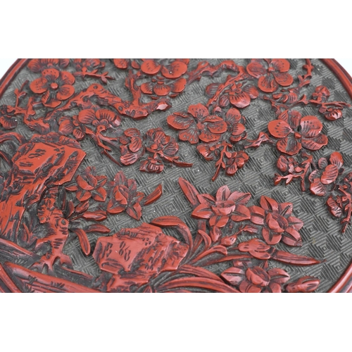 69 - A Chinese Qing dynasty carved cinnabar lacquer box, of cylindrical form, the lid with intricately de... 