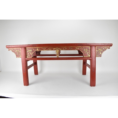 107A - A late 20th century Chinese red painted opium table with a bamboo, slatted top, over a carved and gi... 