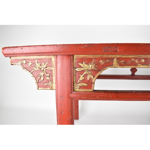 107A - A late 20th century Chinese red painted opium table with a bamboo, slatted top, over a carved and gi... 