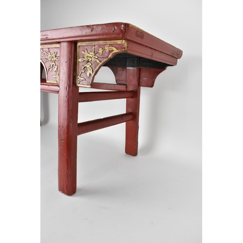 107A - A late 20th century Chinese red painted opium table with a bamboo, slatted top, over a carved and gi... 