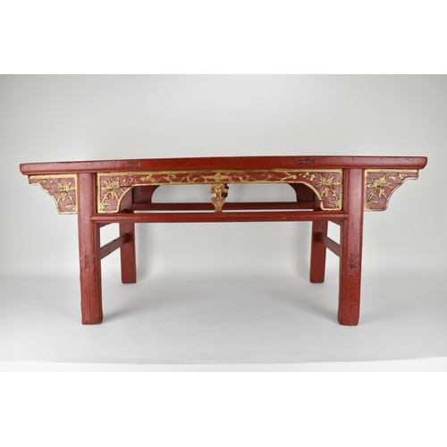 107A - A late 20th century Chinese red painted opium table with a bamboo, slatted top, over a carved and gi... 