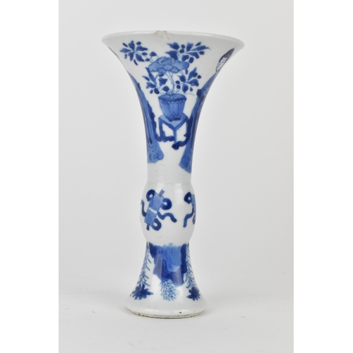 114 - A Chinese Kangxi porcelain blue and white gu vase decorated with two women standing either side of j... 