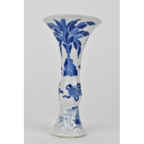 114 - A Chinese Kangxi porcelain blue and white gu vase decorated with two women standing either side of j... 