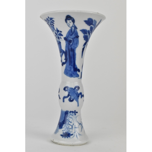 114 - A Chinese Kangxi porcelain blue and white gu vase decorated with two women standing either side of j... 