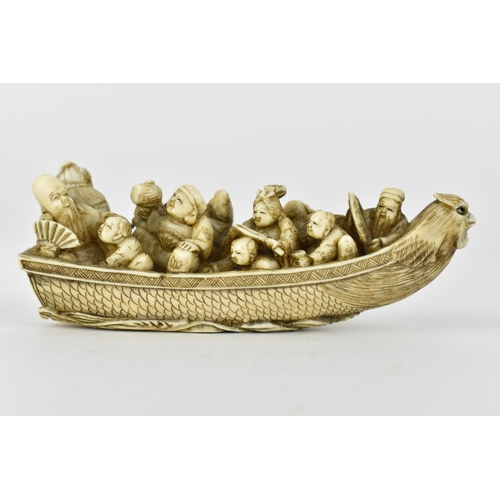 116 - A Japanese Meiji period ivory netsuke of a boat crowed with gods of good fortune, men, women and chi... 