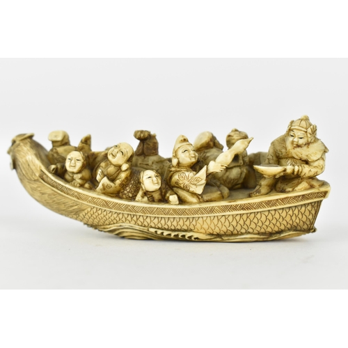 116 - A Japanese Meiji period ivory netsuke of a boat crowed with gods of good fortune, men, women and chi... 