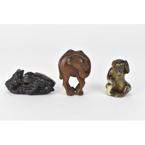 119 - Three 20th century netsuke, one of a camel and another of two frogs on a lily pad, signed to the bas... 