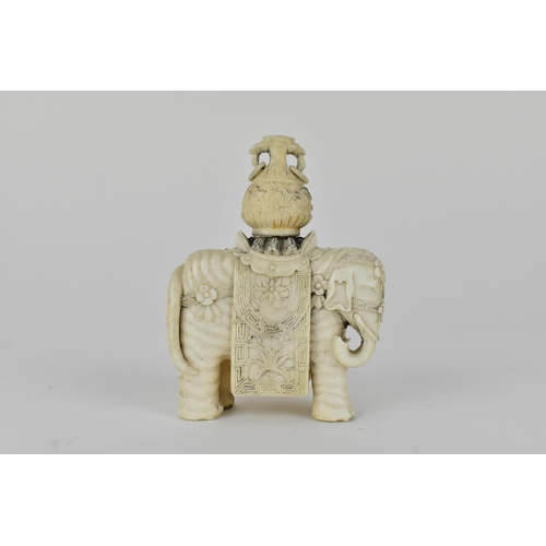 127 - A Chinese carved ivory model elephant decorated with flowers to the harness and draped with a cloth,... 