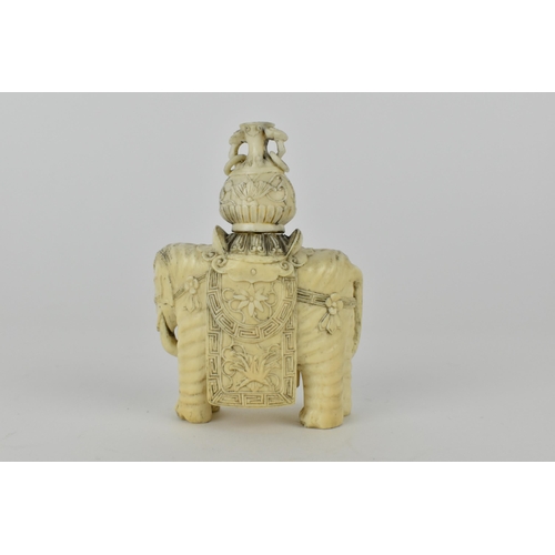 127 - A Chinese carved ivory model elephant decorated with flowers to the harness and draped with a cloth,... 