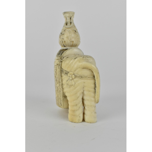 127 - A Chinese carved ivory model elephant decorated with flowers to the harness and draped with a cloth,... 