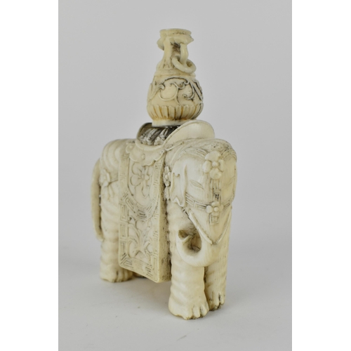 127 - A Chinese carved ivory model elephant decorated with flowers to the harness and draped with a cloth,... 