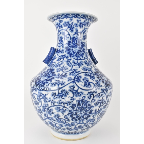 135 - A Chinese late Qing dynasty blue and white hu vase with twin bamboo handles, decorated with entwined... 