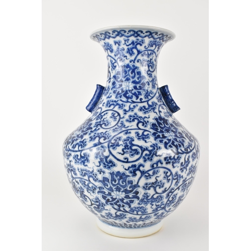 135 - A Chinese late Qing dynasty blue and white hu vase with twin bamboo handles, decorated with entwined... 