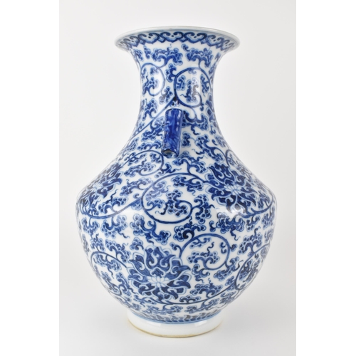 135 - A Chinese late Qing dynasty blue and white hu vase with twin bamboo handles, decorated with entwined... 