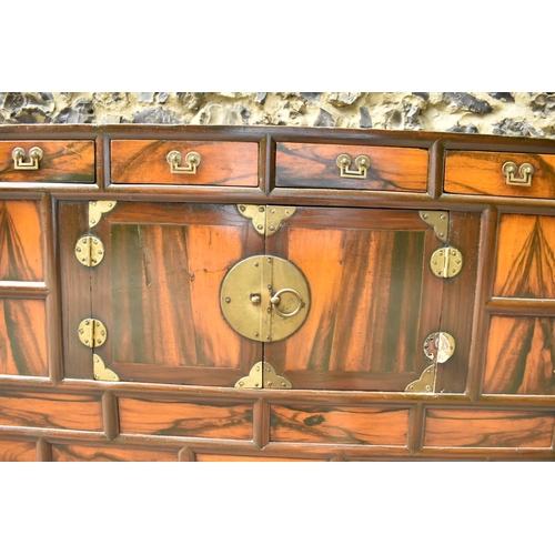 148 - A Korean 19th century two part Tansu cabinet, with brass brackets and handles, with a figured veneer... 