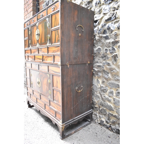 148 - A Korean 19th century two part Tansu cabinet, with brass brackets and handles, with a figured veneer... 