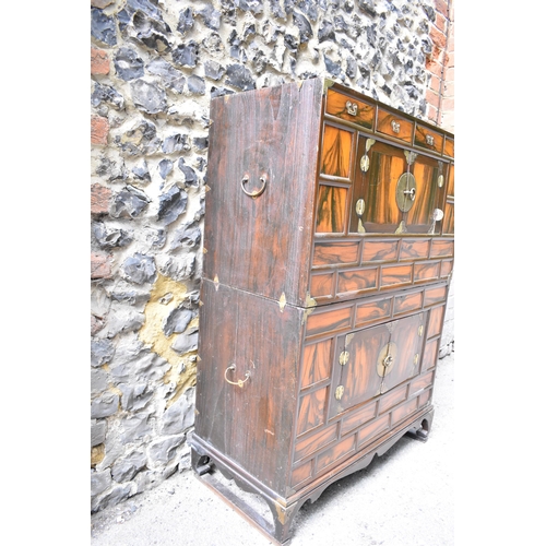 148 - A Korean 19th century two part Tansu cabinet, with brass brackets and handles, with a figured veneer... 