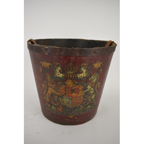 172 - A 19th century painted papermache fire bucket with an armorial device, a leather carrying handle and... 