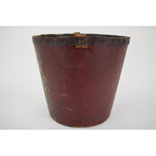 172 - A 19th century painted papermache fire bucket with an armorial device, a leather carrying handle and... 