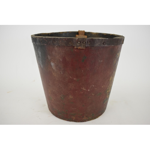 172 - A 19th century painted papermache fire bucket with an armorial device, a leather carrying handle and... 