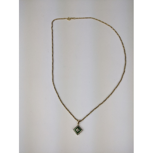 230 - A 9ct gold pendant set with diamonds and green stones, possibly emeralds, 1.2g, on an 18ct gold chai... 