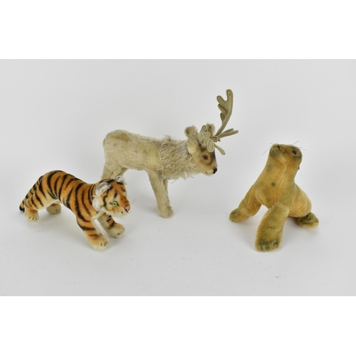 236 - A Steiff seal with a label 17cm high, a reindeer 24cm high to top of antler, a tiger 28cm l
Conditio... 