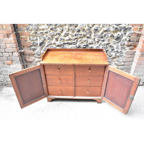 240 - An early 19th century mahogany chest with a galleried top over a pair of panelled doors, enclosing t... 