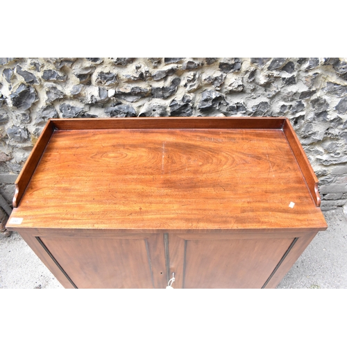 240 - An early 19th century mahogany chest with a galleried top over a pair of panelled doors, enclosing t... 