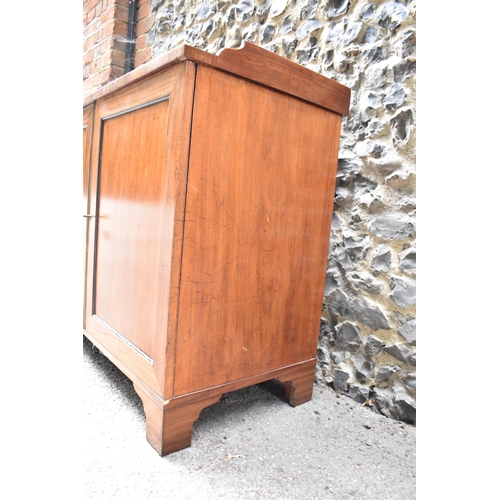 240 - An early 19th century mahogany chest with a galleried top over a pair of panelled doors, enclosing t... 