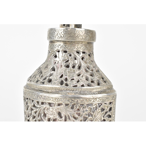 66 - An early 20th century Persian white metal clad glass bottle with a tapered neck, the covering pierce... 