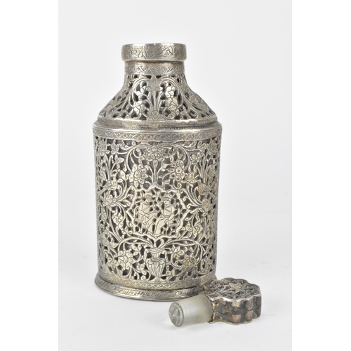 66 - An early 20th century Persian white metal clad glass bottle with a tapered neck, the covering pierce... 