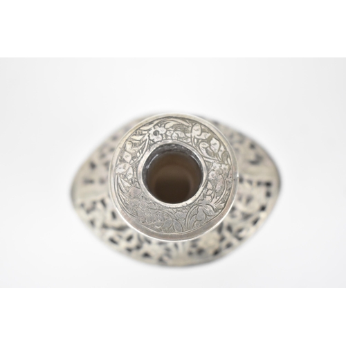 66 - An early 20th century Persian white metal clad glass bottle with a tapered neck, the covering pierce... 