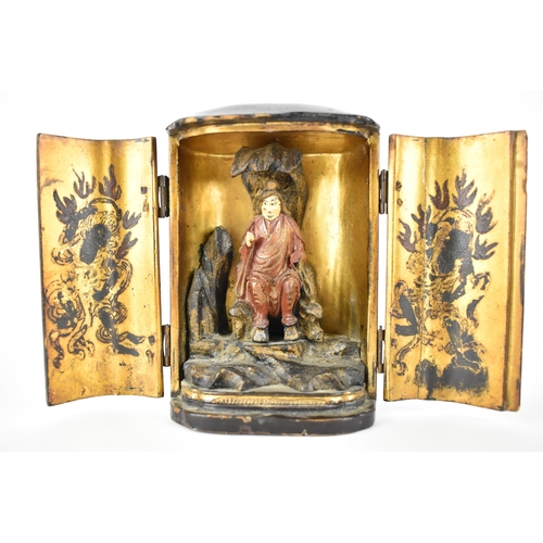 71 - A Chinese lacquered travelling shrine, with a deity seated on rockwork to the interior, with designs... 