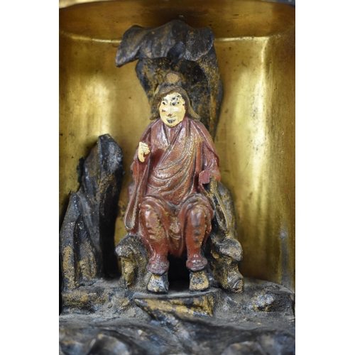 71 - A Chinese lacquered travelling shrine, with a deity seated on rockwork to the interior, with designs... 