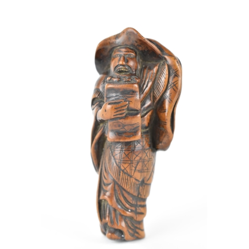 73 - A Japanese Edo period (18th/19th century) wooden netsuke of a scholar holding his hat on, 9.5cm h