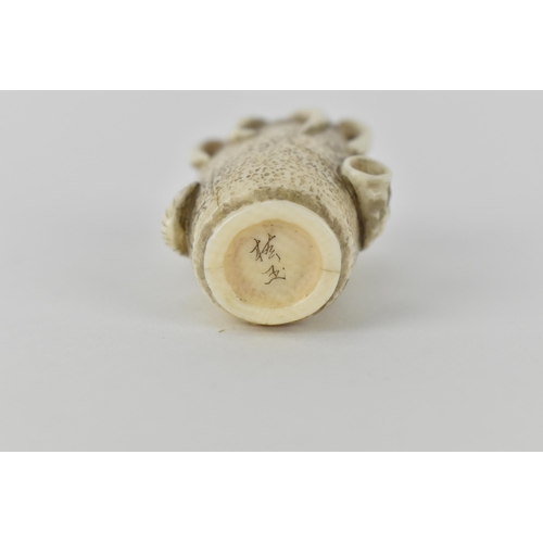 77 - A Japanese Meiji period, late 19th century ivory netsuke of an octopus in a basket with an articulat... 