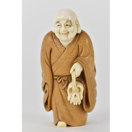 79 - An early 20th century Japanese wood and ivory Okimono of a Chinese man wearing a Kimono carrying a s... 