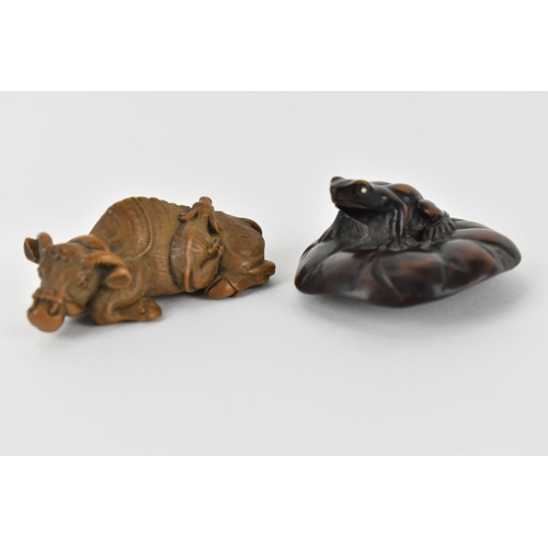 81 - Two early 20th century Japanese wood netsuke of a recumbent water buffalo and its offspring, signed ... 