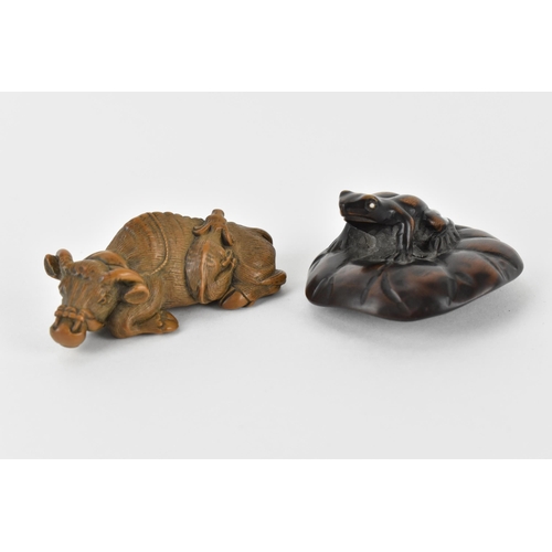 81 - Two early 20th century Japanese wood netsuke of a recumbent water buffalo and its offspring, signed ... 