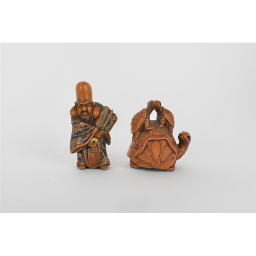 82 - A Quin dynasty and a later wooden netsuke of a deity wearing a robe and holding a fan with painted d... 