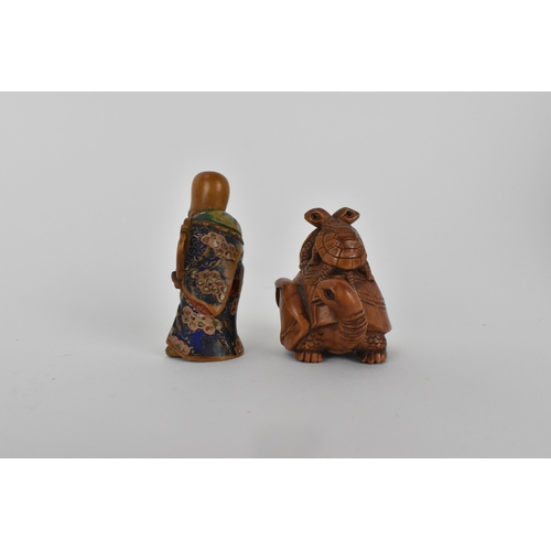 82 - A Quin dynasty and a later wooden netsuke of a deity wearing a robe and holding a fan with painted d... 