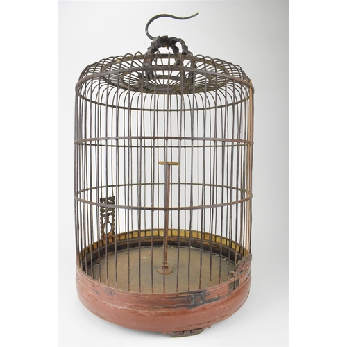 92 - A large 20th century Chinese brown painted wooden bird cage with a metal hook, a central perch and r... 