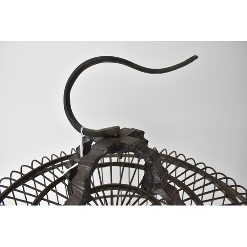 92 - A large 20th century Chinese brown painted wooden bird cage with a metal hook, a central perch and r... 