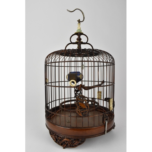 94 - A 20th century Chinese wooden and cane bird cage with a metal hook, a jade and bone finial, bone rin... 