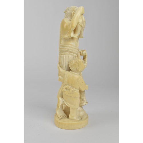 98 - A Japanese Meiji period ivory Okimono of a fisherman holding two fish and a net with a boy by his si... 