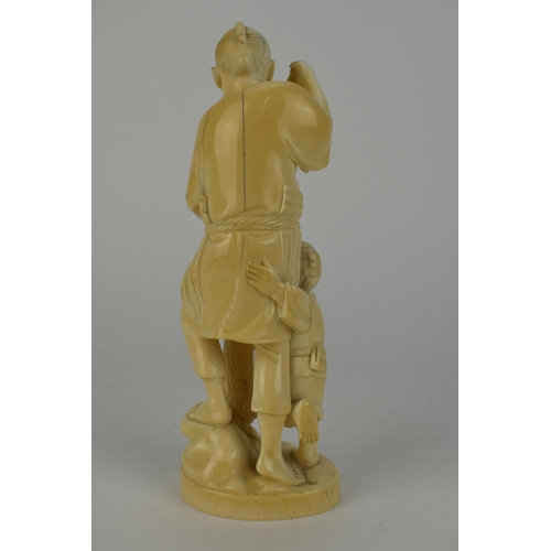 98 - A Japanese Meiji period ivory Okimono of a fisherman holding two fish and a net with a boy by his si... 