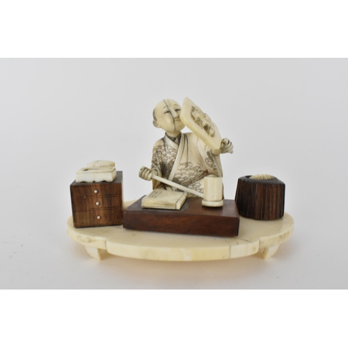 99 - A Japanese Meiji period ivory and wood Okimono of a craftsman holding a mirror with a book in front ... 