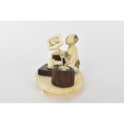 99 - A Japanese Meiji period ivory and wood Okimono of a craftsman holding a mirror with a book in front ... 